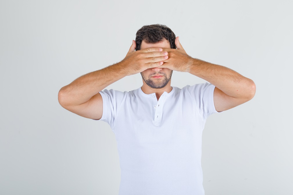 hombre se tapa los ojos demostrando que no puede ver hongos ni bacterias pero si tratarlas con Kipclin