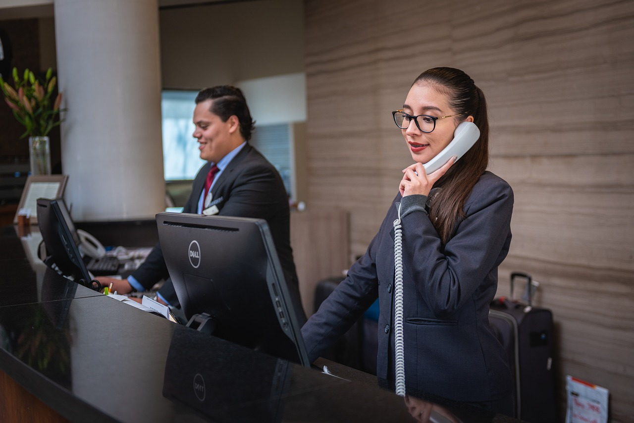 Recepcionista de hotel en Medellín atendiendo el teléfono