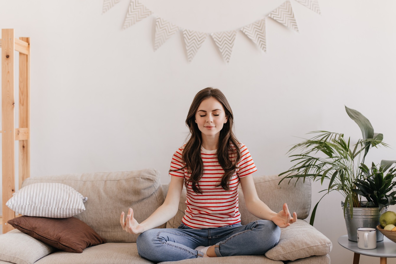 mujer intenta meditar en su habitacion para mantener la calma