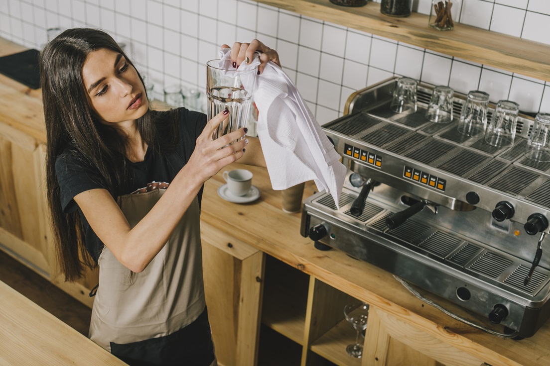 mujer limpiando cristalería en su negocio labor clave con productos de Kipclin