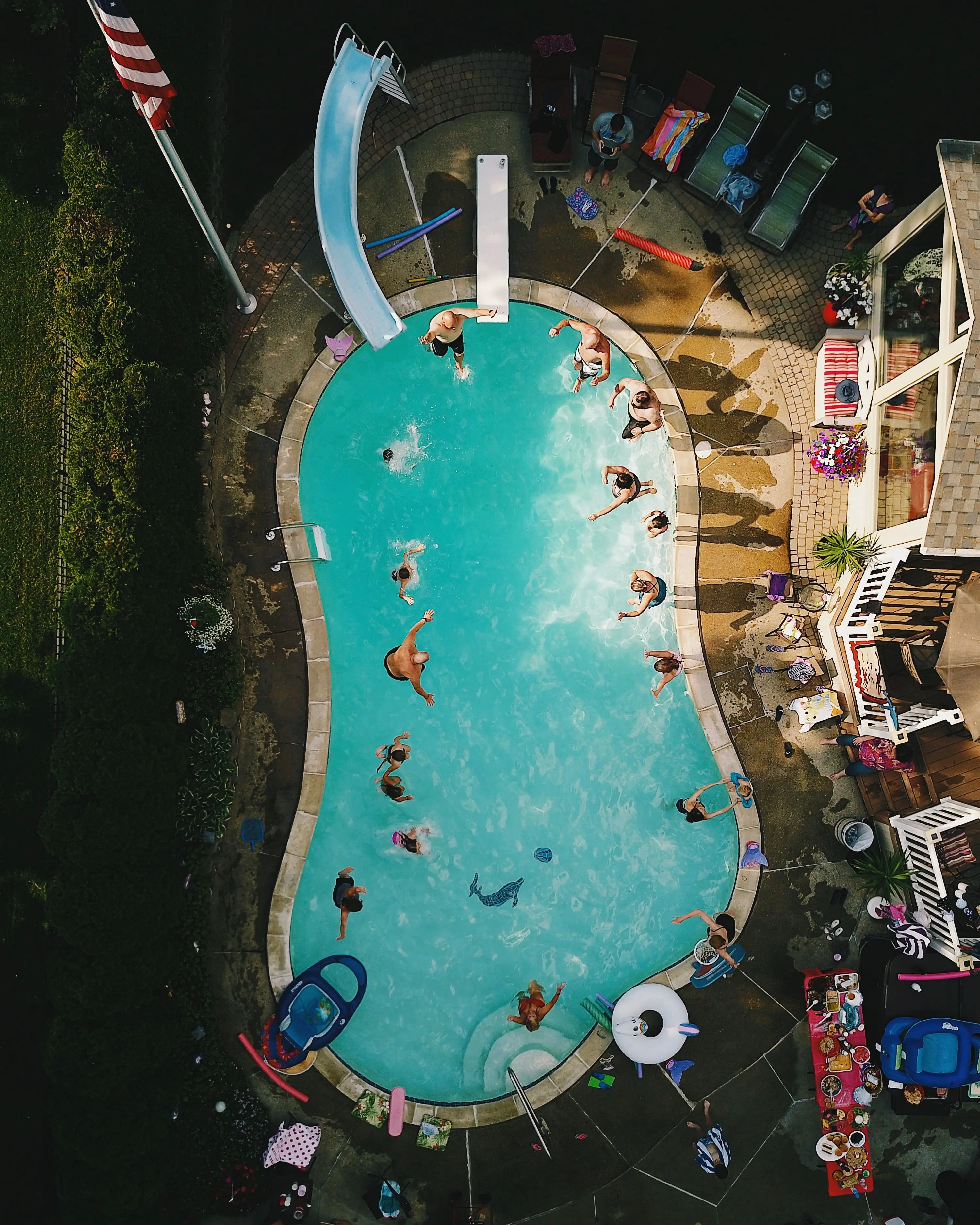 vista de angulo alto vertical de una piscina durante una fiesta bajo la luz del sol 
